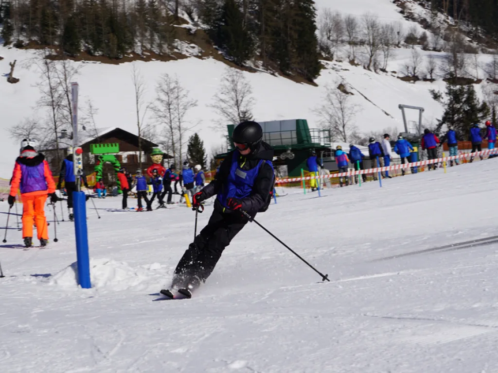 Skifahrer fährt an der Absperrung entlang talwärts.